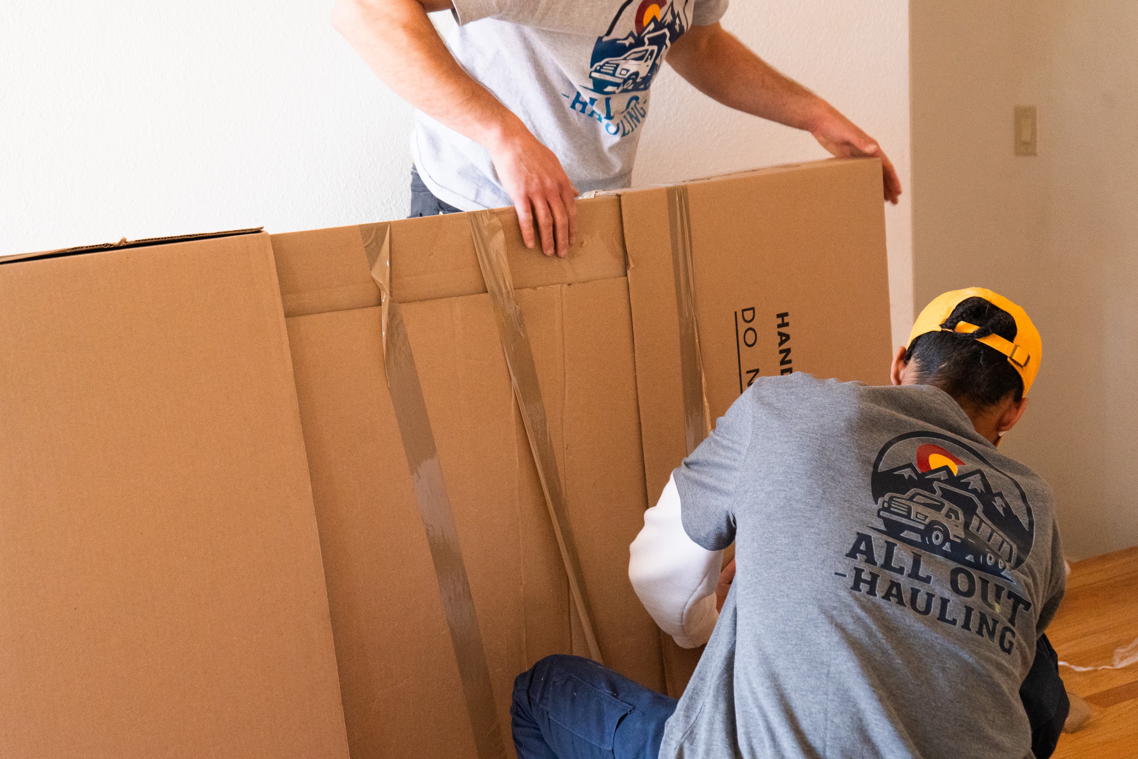 All Out Hauling team positioning a branded moving box